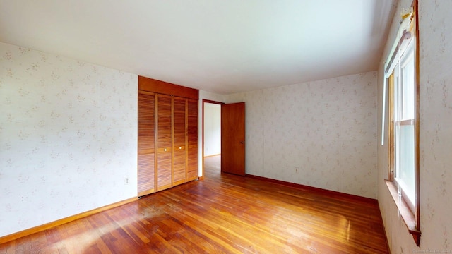 14 Winding Ln, Enfield, CT 06082 - unfurnished bedroom featuring light wood-style floors, a closet, wallpapered walls, and baseboards