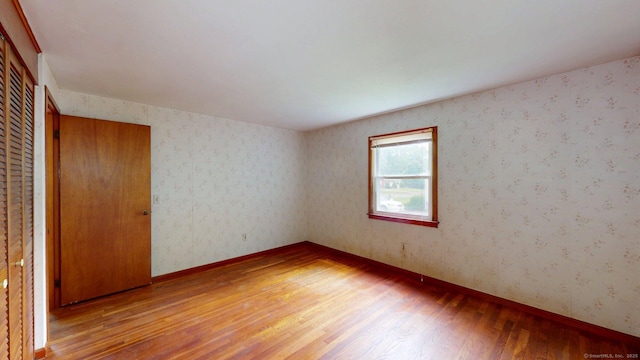 14 Winding Ln, Enfield, CT 06082 - empty room with light wood-style floors, wallpapered walls, and baseboards