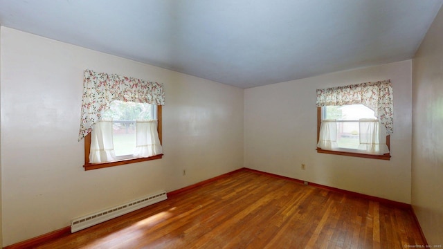 14 Winding Ln, Enfield, CT 06082 - spare room featuring baseboard heating, plenty of natural light, wood finished floors, and baseboards