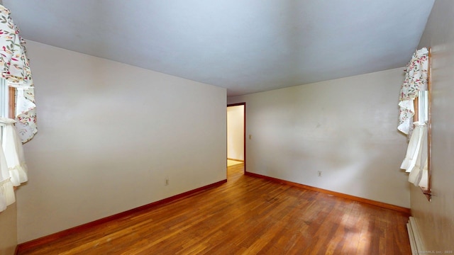 14 Winding Ln, Enfield, CT 06082 - spare room featuring wood finished floors, a baseboard heating unit, and baseboards