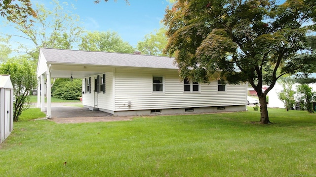 14 Winding Ln, Enfield, CT 06082 - back of house with a lawn, an attached carport, a patio area, and roof with shingles