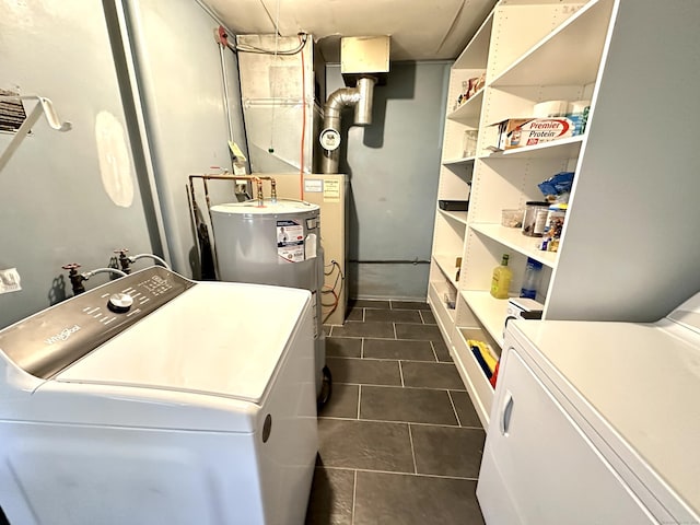laundry room featuring washer and clothes dryer and dark tile patterned flooring
