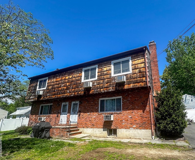 22 Palmer Ave, Stamford, CT 06902 - rear view of house with mansard roof, brick siding, and fence