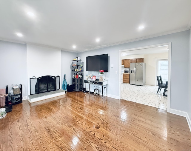 22 Palmer Ave, Stamford, CT 06902 - living room featuring a fireplace with raised hearth, light wood-style floors, crown molding, recessed lighting, and baseboards