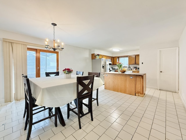 22 Palmer Ave, Stamford, CT 06902 - dining area with a chandelier, healthy amount of natural light, light tile patterned flooring, and baseboards