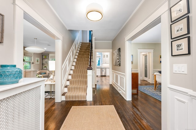 foyer with wood finished floors, stairs, wainscoting, plenty of natural light, and crown molding
