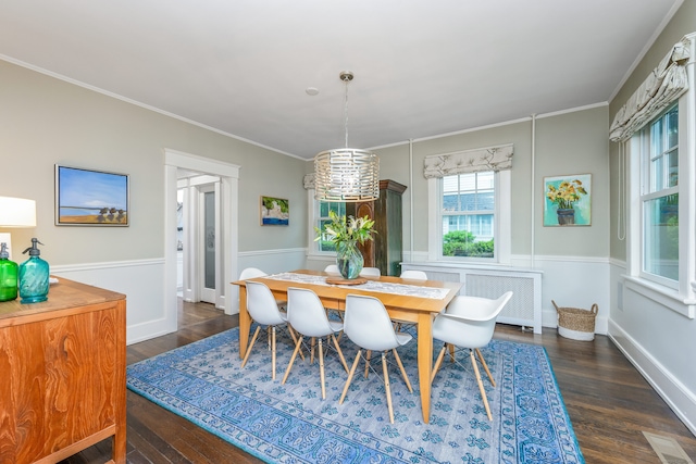dining room featuring dark wood-style floors, ornamental molding, and a chandelier