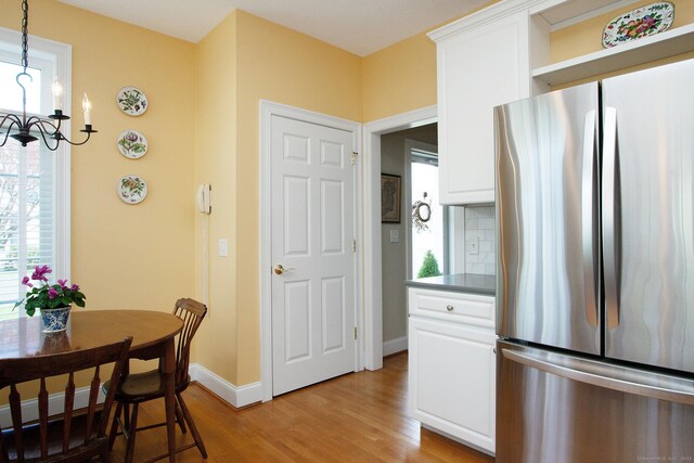 kitchen with freestanding refrigerator, light wood-style floors, and white cabinets