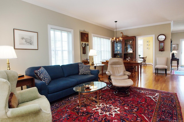 living room featuring a chandelier, wood finished floors, ornamental molding, and baseboards