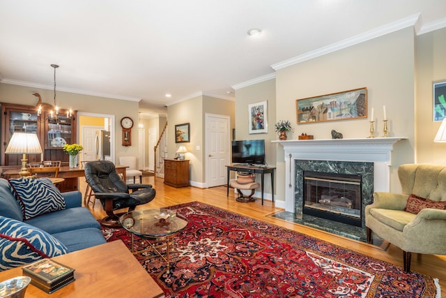 2 Plum Tree Cir, Farmington, CT 06032 - living room featuring light wood-style floors, stairs, crown molding, a fireplace, and a chandelier