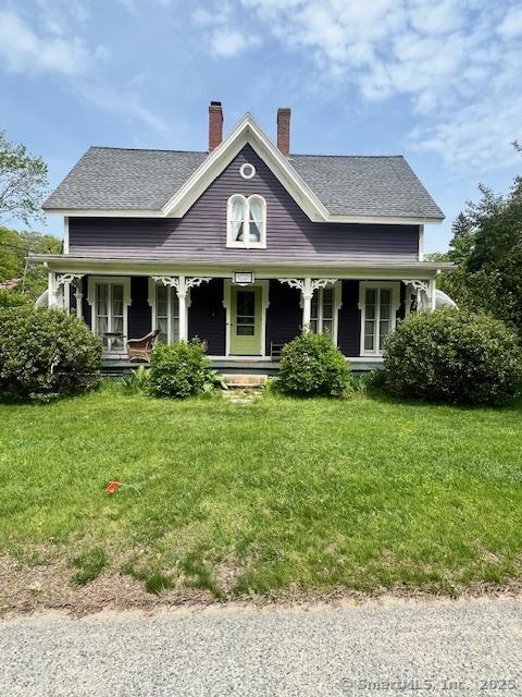 33 Main St, North Stonington, CT 06359 - view of front of house with a front yard, a chimney, a porch, and a shingled roof
