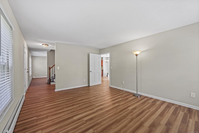 5 Nutmeg Ln, East Hampton, CT 06424 - empty room featuring a baseboard heating unit, wood finished floors, baseboards, and stairs