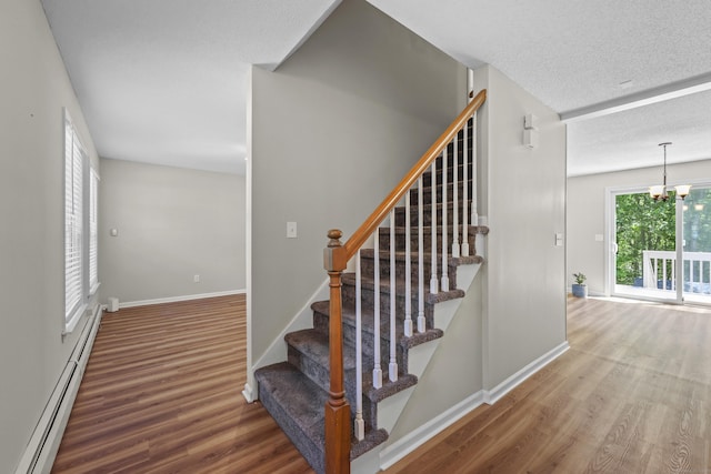 5 Nutmeg Ln, East Hampton, CT 06424 - staircase featuring a baseboard radiator, wood finished floors, baseboards, a chandelier, and a textured ceiling