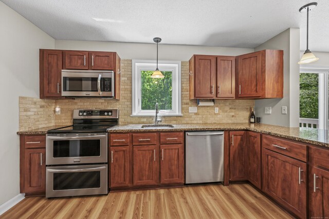 5 Nutmeg Ln, East Hampton, CT 06424 - kitchen featuring appliances with stainless steel finishes, a sink, light wood-style flooring, decorative backsplash, and light stone countertops