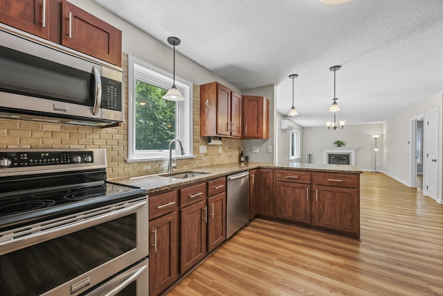 5 Nutmeg Ln, East Hampton, CT 06424 - kitchen with stainless steel appliances, a sink, backsplash, light wood-style floors, and light stone counters
