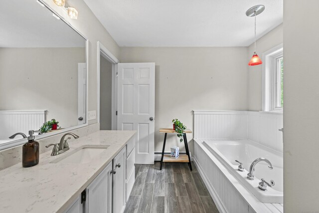 5 Nutmeg Ln, East Hampton, CT 06424 - bathroom featuring vanity, a garden tub, and wood finished floors