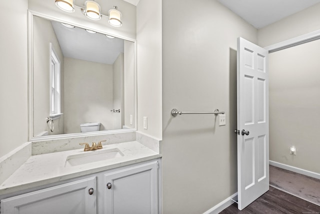 5 Nutmeg Ln, East Hampton, CT 06424 - half bath with vanity, wood finished floors, toilet, and baseboards