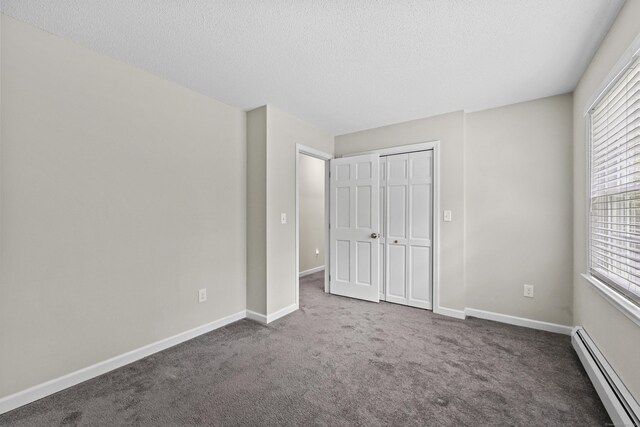 5 Nutmeg Ln, East Hampton, CT 06424 - unfurnished bedroom featuring a baseboard heating unit, carpet flooring, multiple windows, a textured ceiling, and a closet