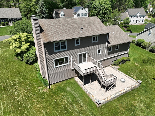 5 Nutmeg Ln, East Hampton, CT 06424 - rear view of house featuring a chimney, a wooden deck, a patio, a yard, and a shingled roof