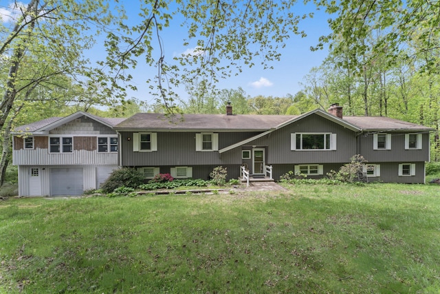view of front of home featuring a chimney, an attached garage, entry steps, and a front lawn