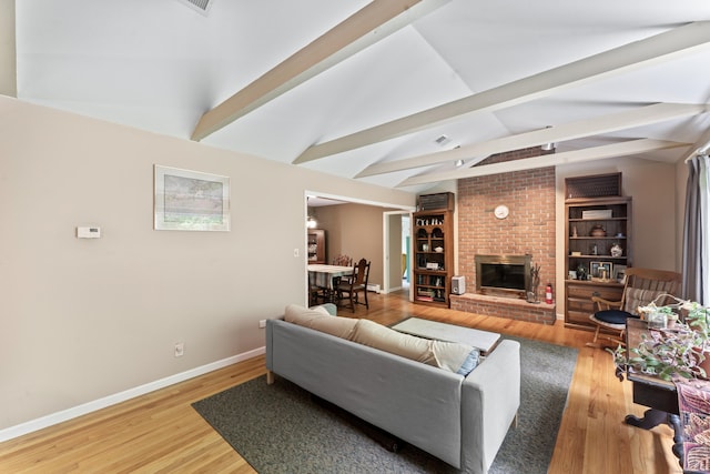 living room featuring light wood-style flooring, baseboards, and a fireplace