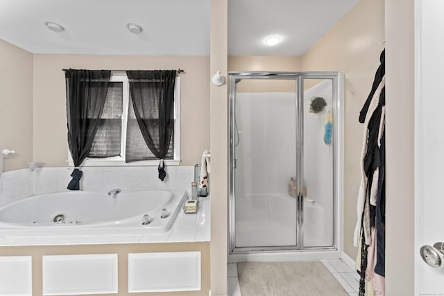 full bathroom with a stall shower, a jetted tub, and tile patterned floors
