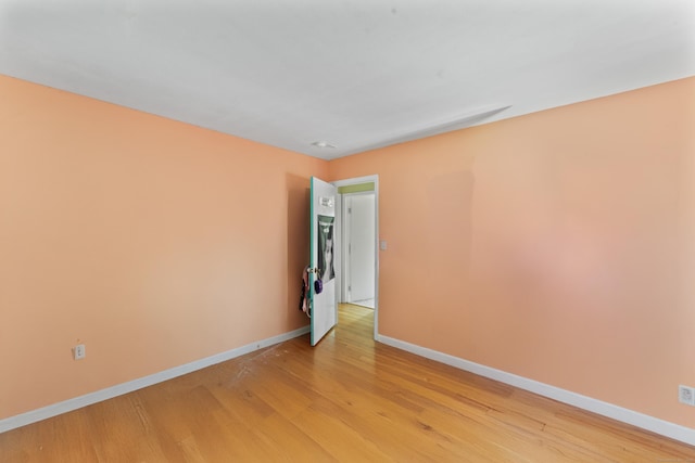 unfurnished room with light wood-style flooring and baseboards
