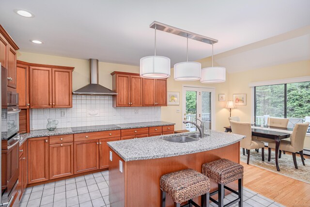 22 Kristy Dr, Bethel, CT 06801 - kitchen with wall chimney range hood, black electric cooktop, brown cabinets, backsplash, and recessed lighting