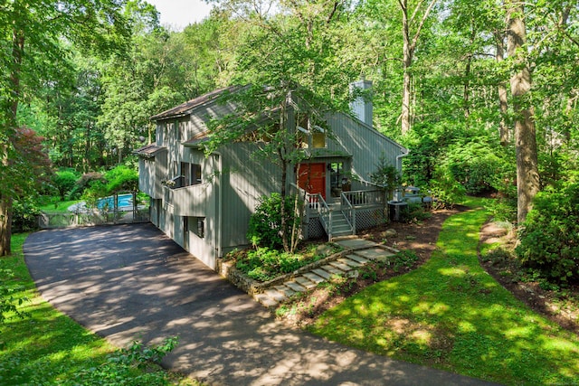 22 Kristy Dr, Bethel, CT 06801 - view of front of house with a chimney, a deck, driveway, and a forest view