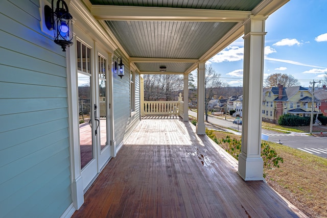 wooden terrace featuring covered porch and a residential view