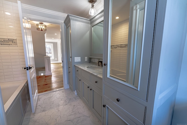 full bathroom featuring vanity, recessed lighting, a bathtub, ornamental molding, and marble finish flooring