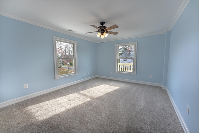 spare room featuring carpet, ornamental molding, a ceiling fan, and baseboards
