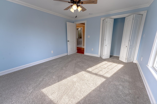 unfurnished bedroom with carpet flooring, ornamental molding, baseboards, a closet, and ceiling fan
