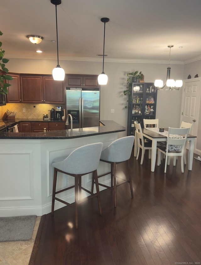95 S Ridge Ln Unit D201, Berlin, CT 06037 - kitchen featuring stainless steel refrigerator with ice dispenser, tasteful backsplash, a breakfast bar area, a chandelier, and hanging light fixtures