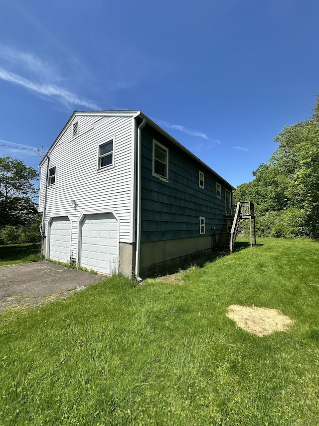 48 Canterbury Dr, Durham, CT 06422 - view of side of property featuring a lawn, asphalt driveway, and a garage