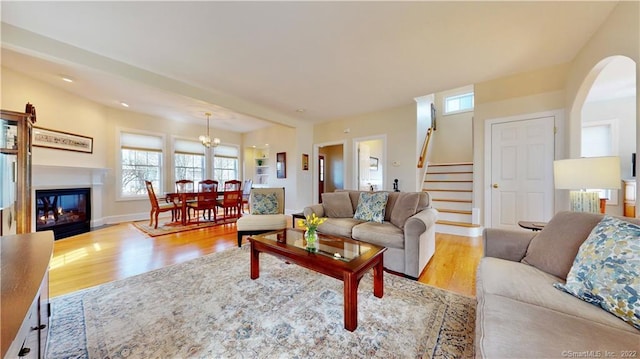 196 Jefferson St, Stratford, CT 06615 - living room with stairs, wood finished floors, a chandelier, and arched walkways