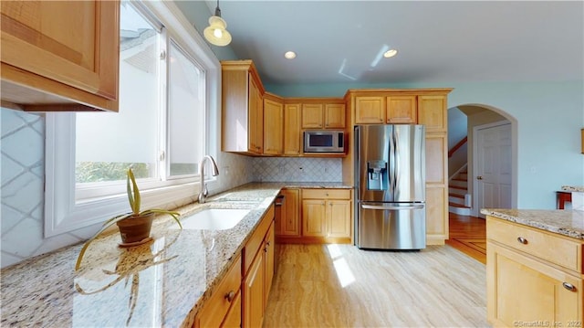 196 Jefferson St, Stratford, CT 06615 - kitchen with appliances with stainless steel finishes, light stone counters, a sink, decorative backsplash, and light wood-style floors