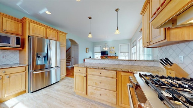 196 Jefferson St, Stratford, CT 06615 - kitchen featuring appliances with stainless steel finishes, arched walkways, under cabinet range hood, a peninsula, and decorative backsplash