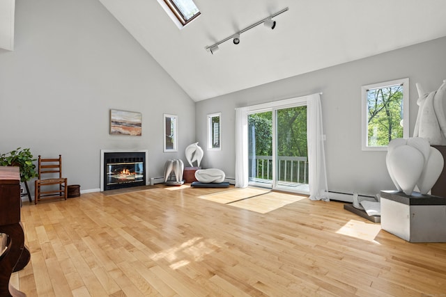 18 Charles St, Groton, CT 06355 - living area featuring rail lighting, high vaulted ceiling, healthy amount of natural light, wood finished floors, and a skylight