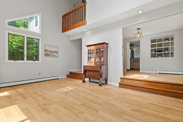 18 Charles St, Groton, CT 06355 - living room featuring baseboard heating, wood finished floors, plenty of natural light, and a high ceiling
