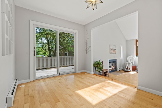 18 Charles St, Groton, CT 06355 - empty room with baseboard heating, a glass covered fireplace, hardwood / wood-style floors, and baseboards