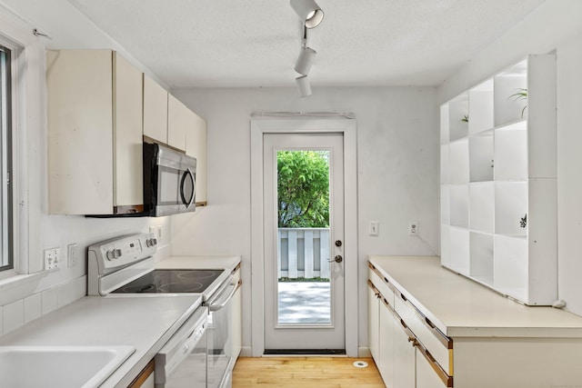 18 Charles St, Groton, CT 06355 - kitchen with white appliances, rail lighting, light countertops, a textured ceiling, and light wood-style floors