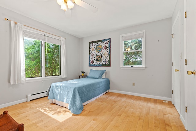 18 Charles St, Groton, CT 06355 - bedroom with a baseboard heating unit, light wood-style flooring, baseboards, and a ceiling fan