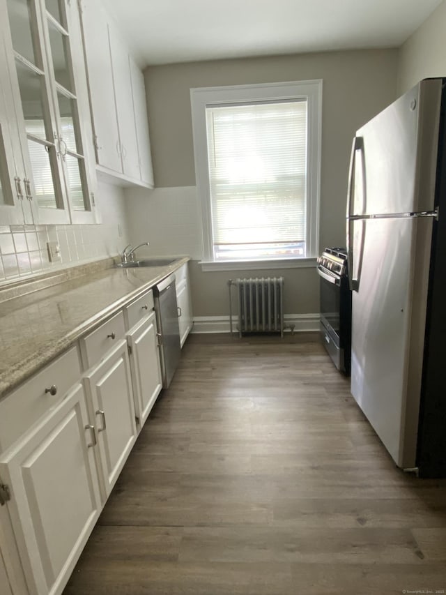 139 Fountain St Apt B9, New Haven, CT 06515 - kitchen featuring stainless steel appliances, radiator heating unit, white cabinetry, and tasteful backsplash