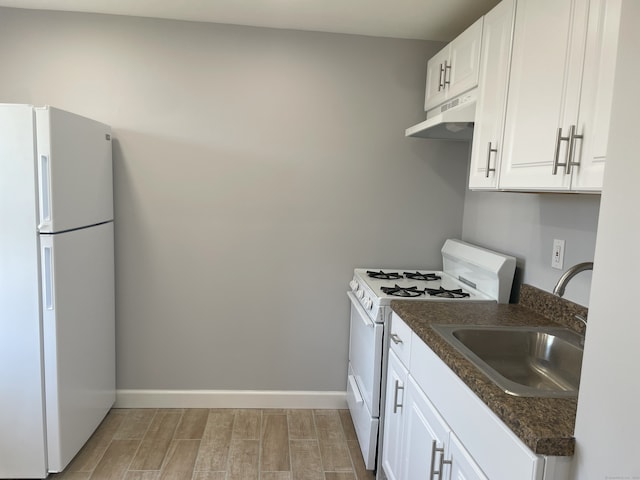 kitchen featuring white appliances, under cabinet range hood, a sink, wood tiled floors, and white cabinetry