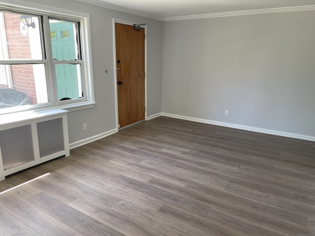 entrance foyer with radiator, ornamental molding, wood finished floors, and baseboards