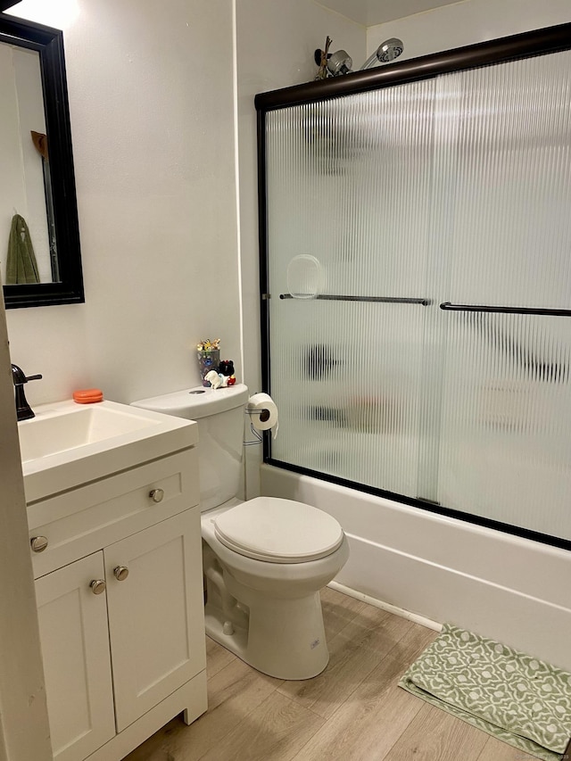 130 Coe Ave Unit 81, East Haven, CT 06512 - bathroom featuring wood finished floors, toilet, vanity, and enclosed tub / shower combo