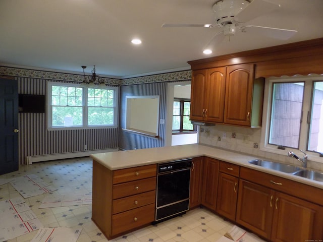 kitchen featuring baseboard heating, brown cabinetry, a sink, a peninsula, and light countertops