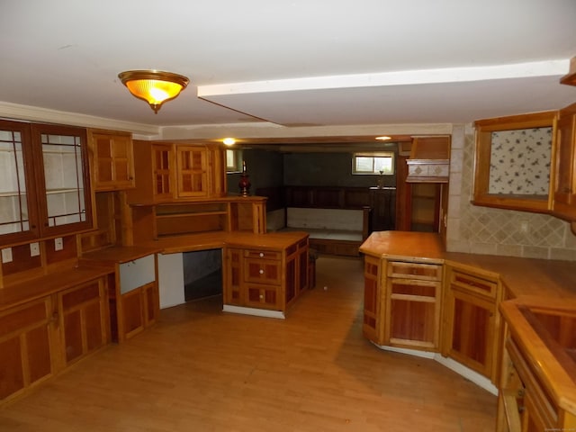 kitchen featuring brown cabinets, light wood finished floors, and glass insert cabinets