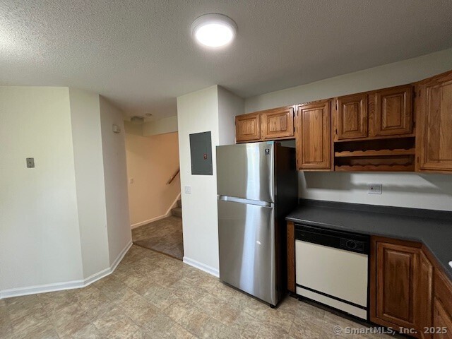 346 Prospect Ave Unit 3, New Haven, CT 06512 - kitchen featuring freestanding refrigerator, dishwasher, dark countertops, baseboards, and brown cabinetry
